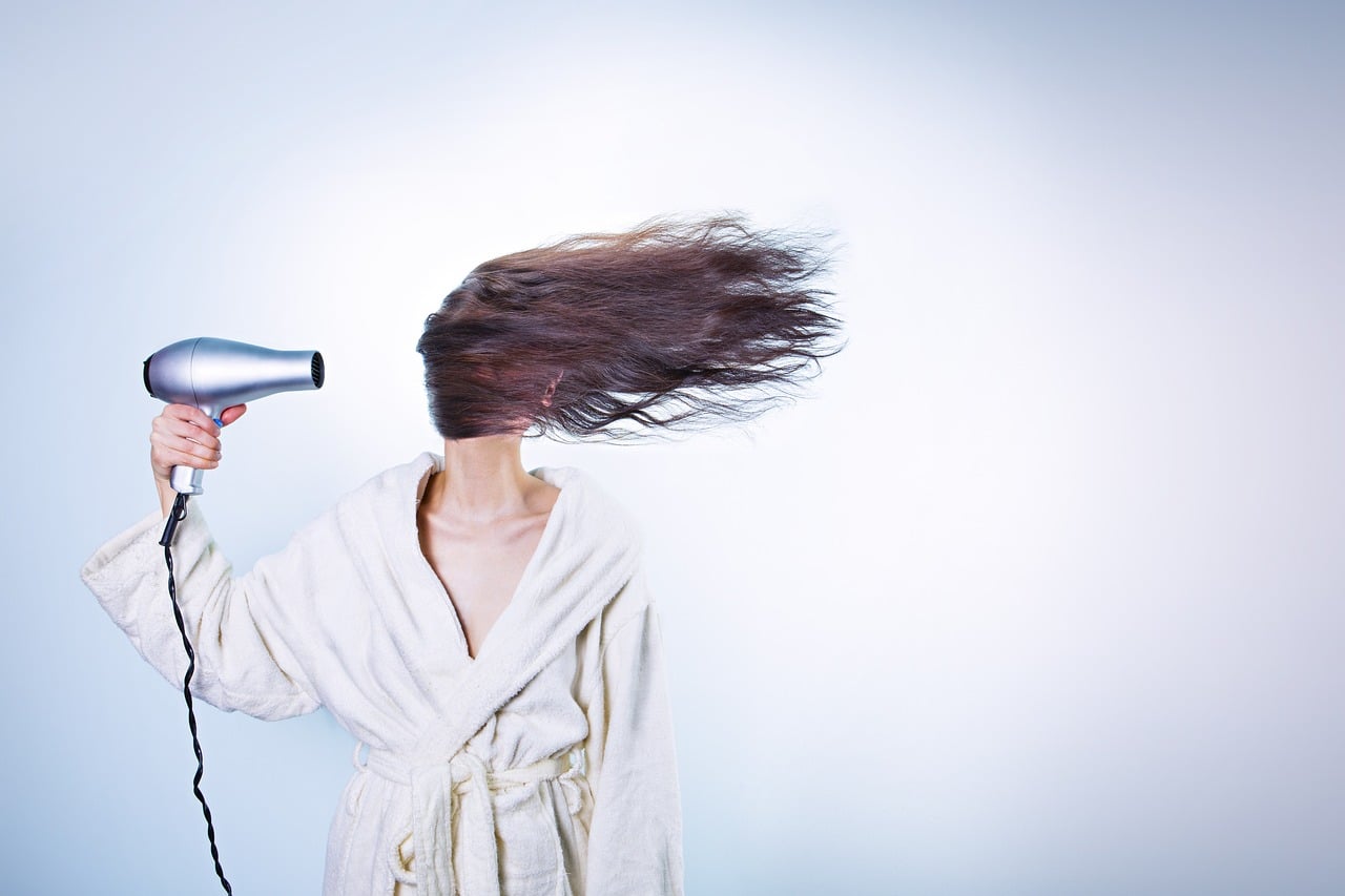 Eine Frau föhnt ihre langen Haare